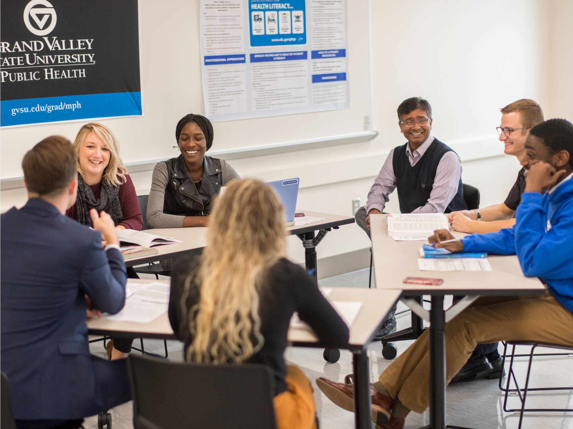 GVSU Public Health Classroom - smiling students and an instructor are participating in a small group discussion